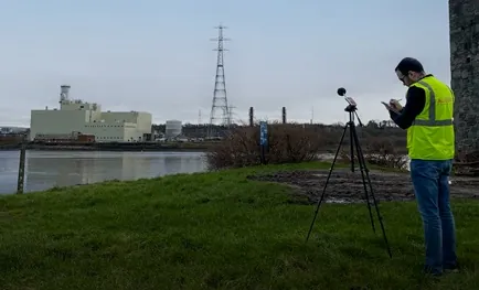 Environmental noise monitoring with a Class 1 sound level meter beside an industrial facility
